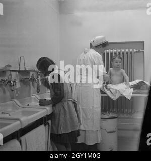 Eine Die Krankenschwester hilft beim Waschen im Mütterheim Dresden auf Schloß Dittersbach, Deutschland 1930 er Jahre. Une infirmière aide les enfants à laver le reste pour les mamans à Dittersbach château près de Dresde, Allemagne 1930. Banque D'Images