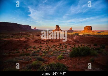 Grand cliché du désert avec une route de terre dans Monument Valley de grandes roches rouges et un ciel bleu Banque D'Images