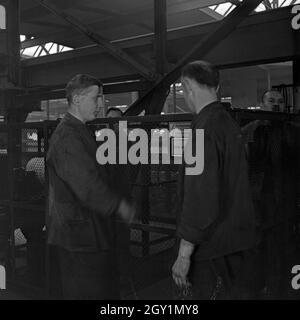 Arbeiter und Schilder zur Avertissement vor Hochspannung im Ausbesserungswerk S-Bahn, Deutschland 1930 er Jahre. Travailleur et signes d'une tension élevée à la préparation, l'usine Allemagne 1930. Banque D'Images