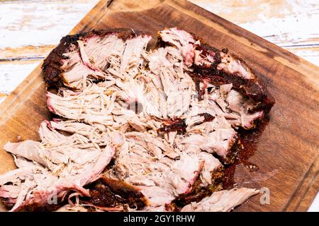 Morceau de porc frotté avec un frottement et cuit sur le barbecue pour faire un porc tiré. Banque D'Images