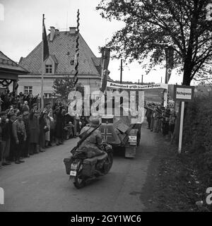 Menschen am Straßenrand bejubeln Führer und Reichskanzler Adolf Hitler BEI seinem Besuch in Asch im Sudetenland, Deutschland 1930er Jahre. Les gens dans les rues applaudissent à Fuehrer et au chancelier Adolf Hitler visitant la ville d'Asch dans le comté de Sudetenland, Allemagne des années 1930. Banque D'Images