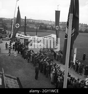 Menschen am Straßenrand bejubeln Führer und Reichskanzler Adolf Hitler BEI seinem Besuch in Asch im Sudetenland, Deutschland 1930er Jahre. Les gens dans les rues applaudissent à Fuehrer et au chancelier Adolf Hitler visitant la ville d'Asch dans le comté de Sudetenland, Allemagne des années 1930. Banque D'Images