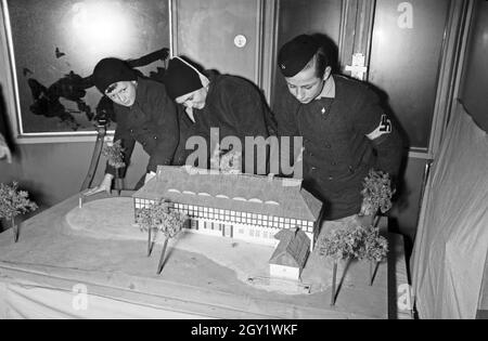 Ausstellungsbesucher informaieren sich auf der 'Sudetenfahrt der deutschen Technik' über die neuesten deutschen Errungenschaften auf dem Gebiet der Technik, hier am Modell der Jugendherberge Demming, Deutschland 1930er Jahre. Visiteurs marchant dans l'exposition de propagande de 'sonderfahrt der deutschen Technik', ici à Demming Youth Hostel model , Allemagne des années 1930. Banque D'Images