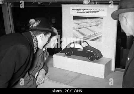 Ausstellungsbesucher informaieren sich auf der 'Sudetenfahrt der deutschen Technik' über die neuesten deutschen Errungenschaften auf dem Gebiet der Technik, hier der KDF Wagen von Deutschland, 1930er Jahre. Visiteurs marchant dans l'exposition de propagande 'sonderfahrt der deutschen Technik', ici le coléoptère Volkswagen, Allemagne des années 1930. Banque D'Images