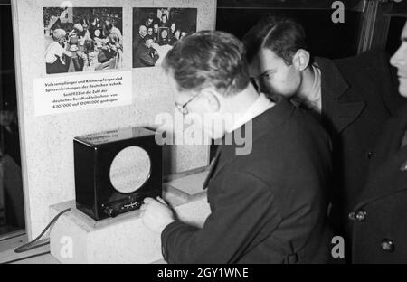 Ausstellungsbesucher informaieren sich auf der 'Sudetenfahrt der deutschen Technik' über die neuesten deutschen Errungenschaften auf dem Gebiet der Technik, hier das Volkssempfänger radio, Deutschland 1930er Jahre. Visiteurs marchant dans l'exposition de propagande de 'sonderfahrt der deutschen Technik', ici la radio Volksmfänger, Allemagne des années 1930. Banque D'Images