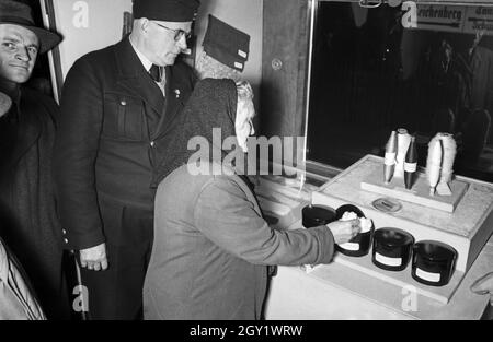 Ausstellungsbesucher informaieren sich auf der 'Sudetenfahrt der deutschen Technik' über die neuesten deutschen Errungenschaften auf dem Gebiet der Technik, hier BEI verschiedenen Wollstoffen, Deutschland 1930er Jahre. Visiteurs marchant à travers l'exposition de propagande 'sonderfahrt der deutschen Technik', ici avec whool artificiel, Allemagne des années 1930. Banque D'Images