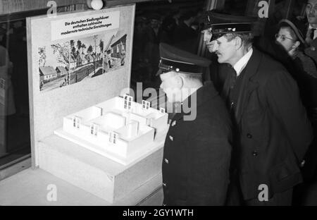 Ausstellungsbesucher informaieren sich auf der 'Sudetenfahrt der deutschen Technik' über die neuesten deutschen Errungenschaften auf dem Gebiet der Technik, Neubeim Grundriss er deutscher Siedlungshäuser, Deutschland 1930er Jahre. Visiteurs marchant dans l'exposition de propagande 'sonderfahrt der deutschen Technik', ici au modèle de nouvelles maisons de peuplement allemandes, l'Allemagne des années 1930. Banque D'Images