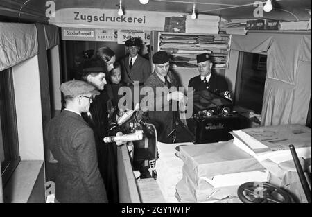 Ausstellungsbesucher informaieren sich auf der 'Sudetenfahrt der deutschen Technik' über die neuesten deutschen Errungenschaften auf dem Gebiet der Technik, hier in der mobilen Druckerei des Zuges, Deutschland 1930er Jahre. Visiteurs marchant dans l'exposition de propagande 'sonderfahrt der deutschen Technik', ici au bureau d'impression mobile du train, Allemagne des années 1930. Banque D'Images