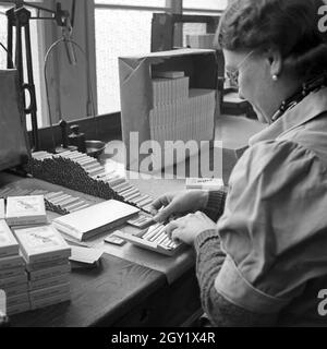 Arbeitsalltag in der Zigarettenfabrik, hier beim Zigarettenrollen, Deutschland 1930er Jahre. Journée de travail dans une usine de cigarettes, ici: Femme roulant des cigarettes, Allemagne des années 1930. Banque D'Images