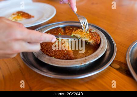 Kunefe kunafa dessert turc, kadayif, à la pistache en poudre et le fromage, servi chaud, très doux. Dessert traditionnel turc Banque D'Images