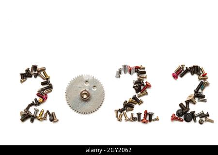 2022 écrit avec de minuscules vis et une roue dentée , isolée sur blanc.Prise de vue macro. Banque D'Images