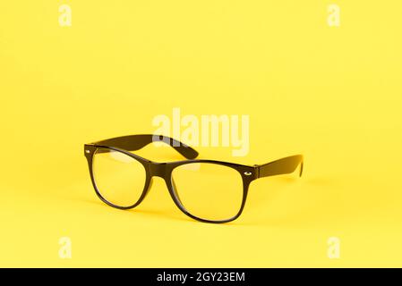 Verres optiques à cadre noir isolés sur fond jaune Banque D'Images