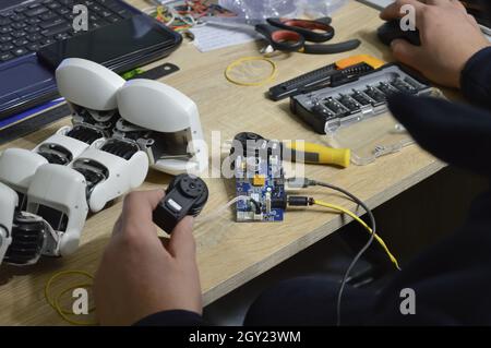 homme réparant un robot.Gros plan des mains mâles fixant un petit robot cassé Banque D'Images