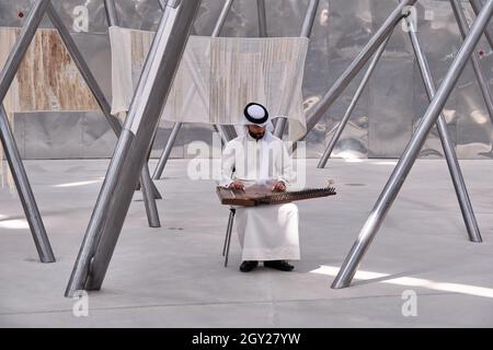 Un musicien bahreïni jouant une zither à l'intérieur du pavillon du Royaume de Bahreïn dans la section Opportunity District de la Dubai Expo 2020, Dubaï, Émirats Arabes Unis Banque D'Images