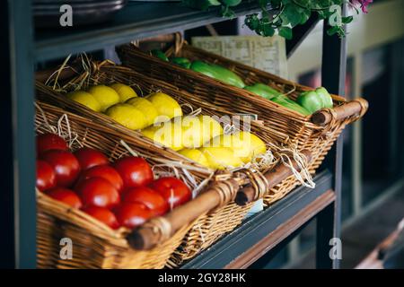 Légumes en paniers, tomates rouges, citrons jaunes, poivron vert.Cuisine ouverte concept de restaurant Banque D'Images