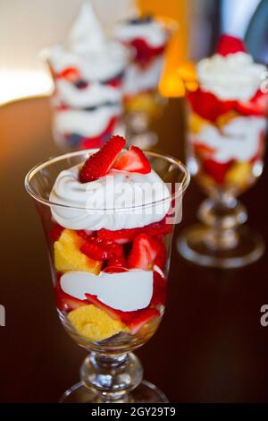 Parfait aux fruits mélangés dans un verre transparent aux couches colorées et recouvert de fraises Banque D'Images