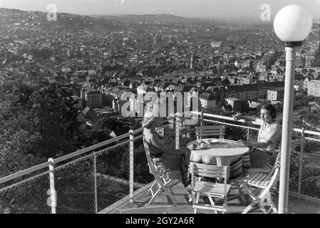 Zwei junge Frauen genießen von der Caféterrasse aus den Blick über Stuttgart, Deutschland 1930 er Jahre. Deux jeunes femmes profitez de la vue sur Stuttgart à partir de la terrasse d'un café, de l'Allemagne des années 1930. Banque D'Images