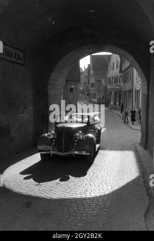 Fahrt mit dem Ford V8 durch den Beinsteiner Torturm à Waiblingen, Deutschland 1930 er Jahre. La conduite par les Beinsteiner Gate Tower à Waiblingen avec une Ford V8, l'Allemagne des années 1930. Banque D'Images