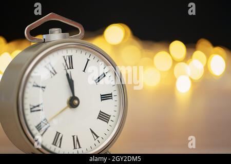Gros plan du réveil rétro sur fond flou de Noël avec bokeh Banque D'Images