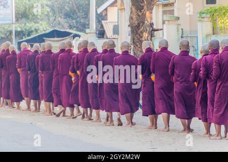 BAGAN, MYANMAR - 8 DÉCEMBRE 2016: Rangée de jeunes moines bouddhistes collectant leurs almes quotidiens. Banque D'Images