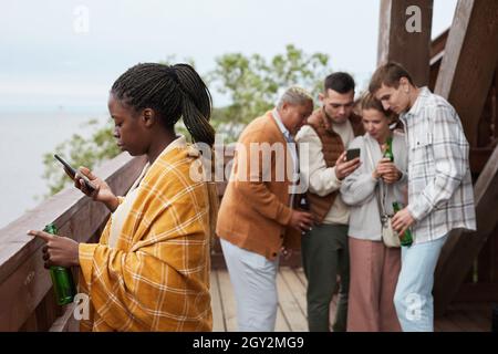 Divers groupes de jeunes se détendant sur le balcon pendant la fête à Lake House Banque D'Images