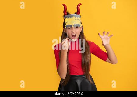 enfant méchant dans des cornes imp avec accessoire de fête. joyeux halloween. diable enfant avec citrouille. Banque D'Images