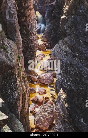Petit canyon avec rochers tombés et chute d'eau à la fin Banque D'Images