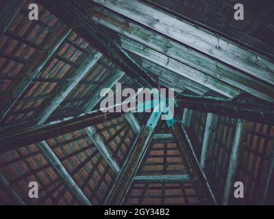 Vue de dessous d'un cadre de toit constitué de poutres en bois reliées à des éléments métalliques Banque D'Images