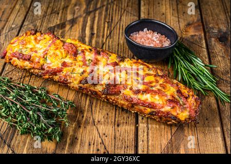 Sandwich pizza sur pain de baguette avec jambon, bacon, légumes et fromage sur table en bois. fond en bois. Vue de dessus Banque D'Images