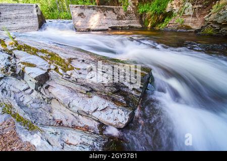 Barrage en ciment de la rivière de l'entonnoir avec grand affleurement de pierre couvert de mousse Banque D'Images