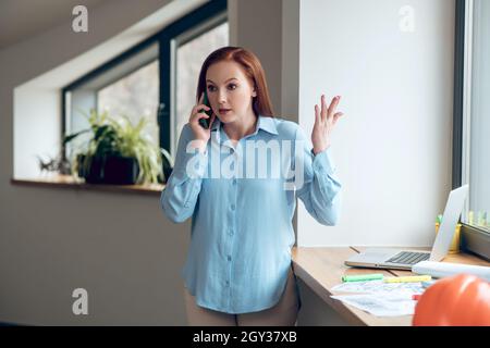 Jeune femme confiante communiquant par téléphone intelligent Banque D'Images