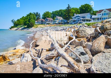 Maison en bord de mer sur lac et plage de sable avec bois de grève et pierres Banque D'Images