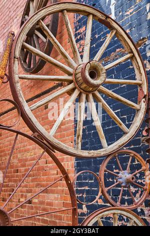 Anciennes roues de chariot dans le collage contre le bâtiment de brique Banque D'Images