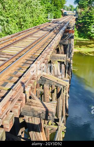 Vue latérale sur le dessus du pont de chemin de fer du vieux bois sur l'eau Banque D'Images