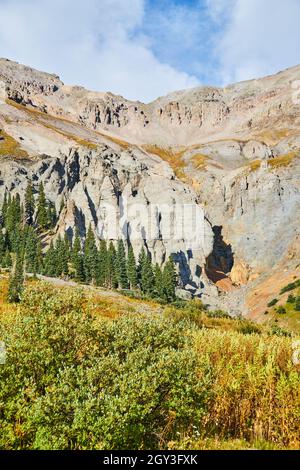 Vue sur les sommets de montagne gris au début de l'automne avec pins et croissance Banque D'Images