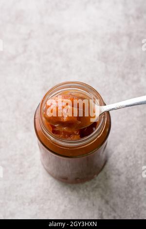 confiture d'ambarella ou de prune de juin dans un pot avec une cuillère, vue rapprochée Banque D'Images