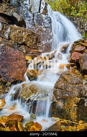 Vue rapprochée de la petite cascade sur les rochers rouges et bruns Banque D'Images