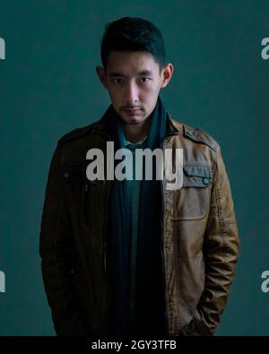 Portrait d'un bel homme asiatique sérieux portant une veste en cuir marron Banque D'Images