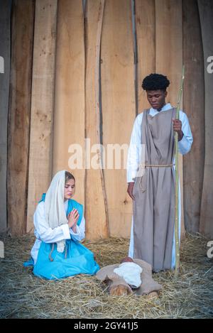 Scène de nativité verticale avec personnages multiethniques dans un berceau Banque D'Images