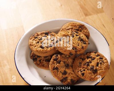 biscuits aux pépites de chocolat sur une table en bois biscuits aux pépites de chocolat sur une assiette en étain sur une table en bois Banque D'Images