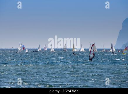 Planche à voile surf et voiliers naviguant sur les vagues du lac Lago di Garda Banque D'Images