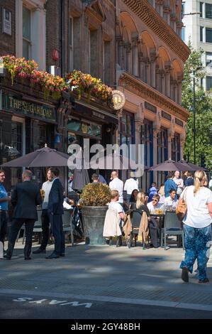 Les employés de la ville apprécient un déjeuner-boisson lors d'une chaude journée ensoleillée à l'extérieur du pub Sugarloaf.Cannon Street, City of London, Angleterre, Royaume-Uni. Banque D'Images