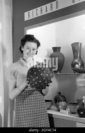 Eine der Leipziger Frühjahrsmesse Besucherin vor einem Stand der Porzellanmanufaktur Richard Ginori, Deutschland 1941. Un visiteur de la Leipziger Frühjahrsmesse devant un stand de l'usine de porcelaine Richard Ginori, Allemagne 1941. Banque D'Images