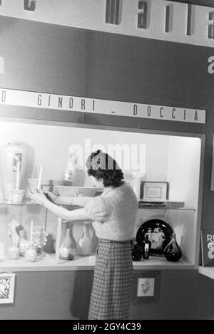 Eine der Leipziger Frühjahrsmesse Besucherin vor einem Stand der Porzellanmanufaktur Richard Ginori, Deutschland 1941. Un visiteur de la Leipziger Frühjahrsmesse devant un stand de l'usine de porcelaine Richard Ginori, Allemagne 1941. Banque D'Images