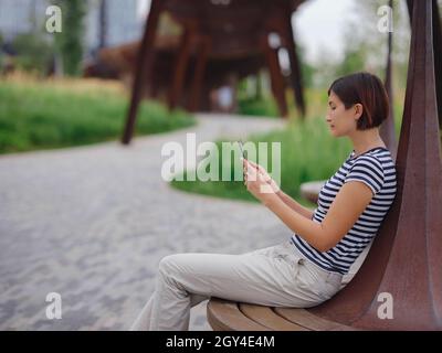 belle jeune femme asiatique passant du temps dans un parc urbain contemporain le jour de l'été. Banque D'Images