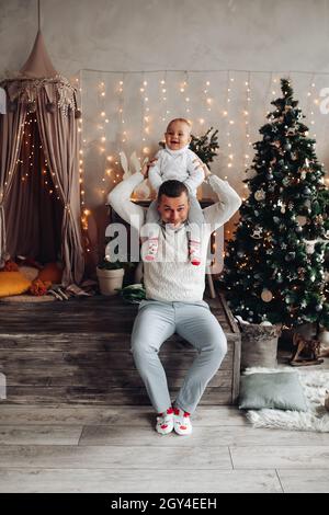 Un père fort tient sa petite fille sur ses épaules et sourit Banque D'Images