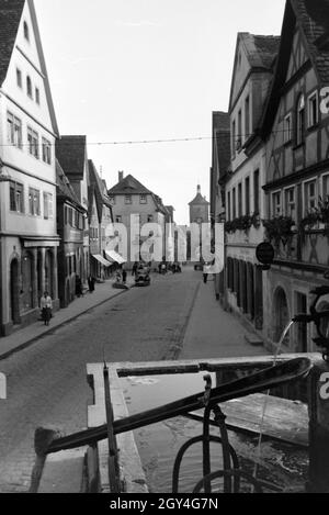 Eine von gesäumte Fachwerkhäusern Straße mit einem Springbrunnen à Rothenburg ob der Tauber, Allemagne Allemagne Années 1930 er Jahre. Une rue bordée de maisons à colombage et une fontaine à Rothenburg ob der Tauber, Allemagne 1930. Banque D'Images