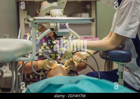 Traitement dentaire au microscope.Femme ayant des dents examinées chez les dentistes.Rendez-vous chez le dentiste. Style de vie, vie réelle Banque D'Images