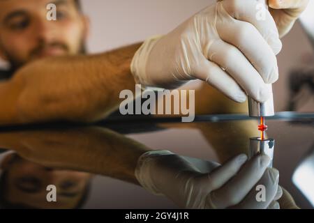 Photo d'un débosselage de procédé sans peinture, un jeune professionnel effectue une réparation de débosselage sur le toit de la voiture dans le service. Banque D'Images