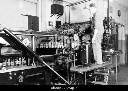 Ein Arbeiter kontrolliert mourir dans Rotationsdruckmaschine Maschinenbaukonzerns den Werken des MAN (Maschinenfabrik Augsburg-Nürnberg), Deutschland 1930 er Jahre. Un travailleur le contrôle de la presse d'impression rotative dans les usines de la société d'ingénierie mécanique (homme), Maschinenfabrik Augsburg-Nürnberg Allemagne 1930. Banque D'Images